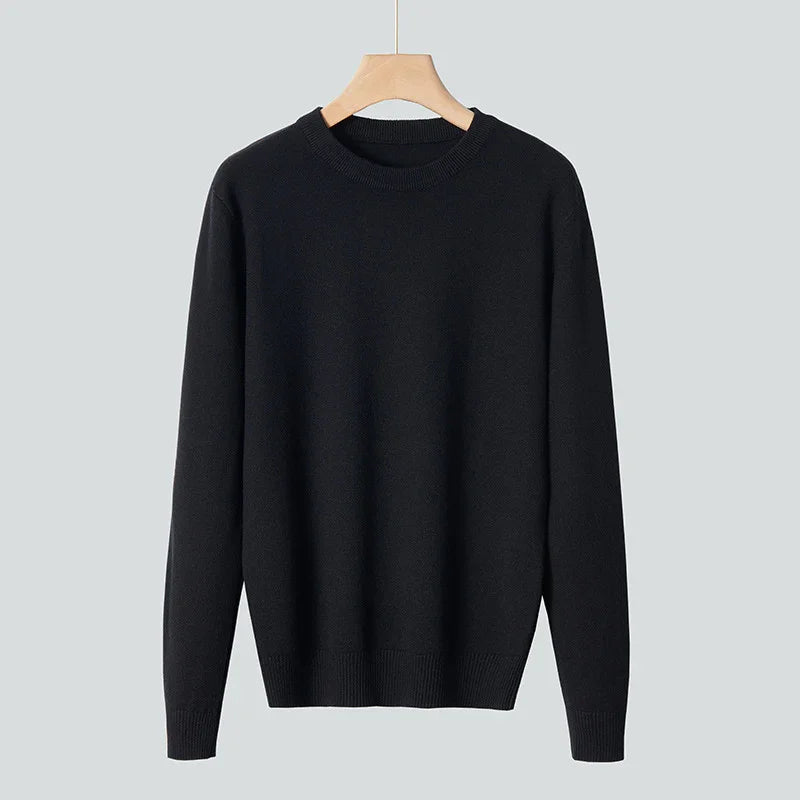 Classic black crewneck sweater with long sleeves hanging on wooden hanger against gray background