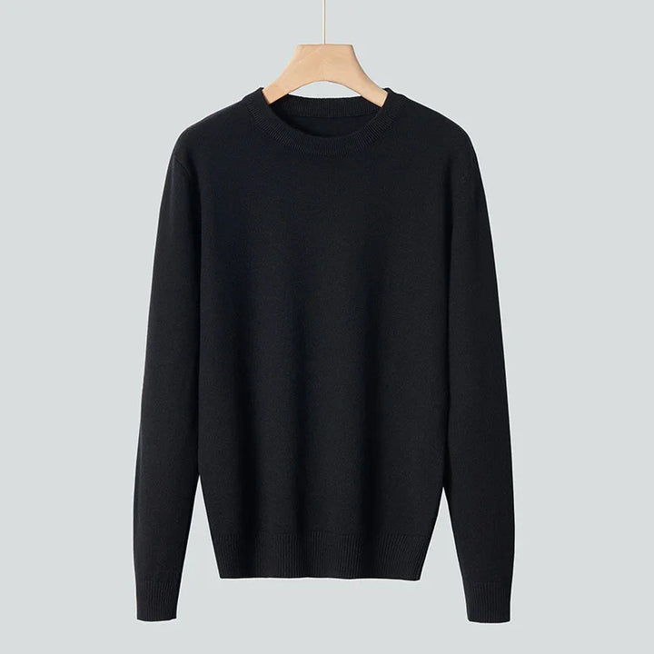 Classic black crewneck sweater with long sleeves hanging on wooden hanger against gray background