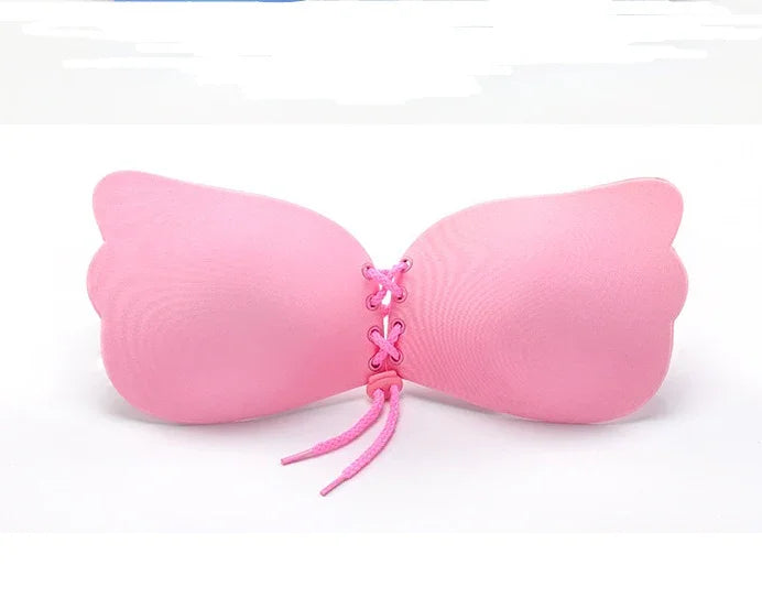 Pink strapless adhesive bra with lace-up front closure on white background