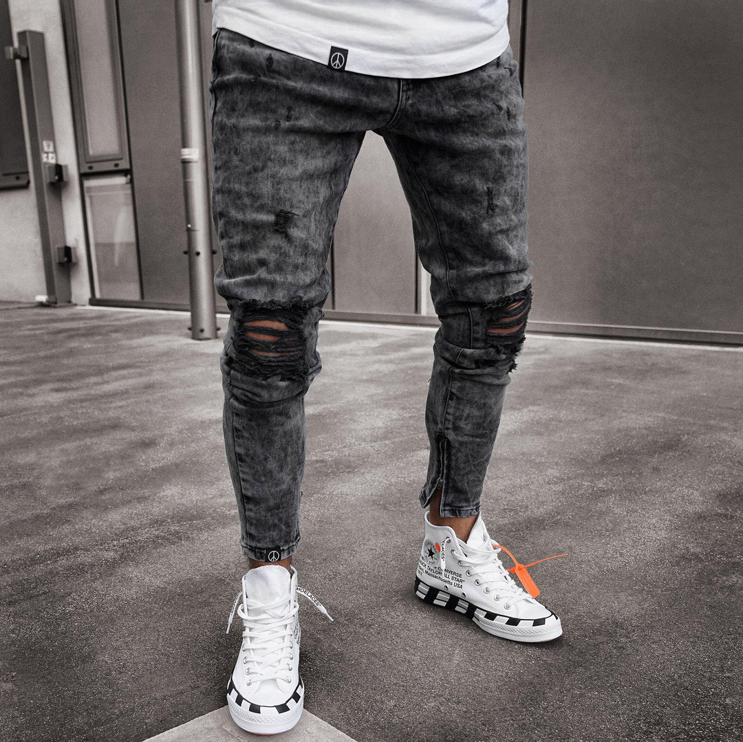 Man wearing black ripped skinny jeans and white high-top sneakers with black checkered soles