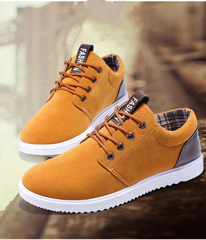 Casual mustard yellow lace-up sneakers with white soles and brown heel detail on a reflective surface