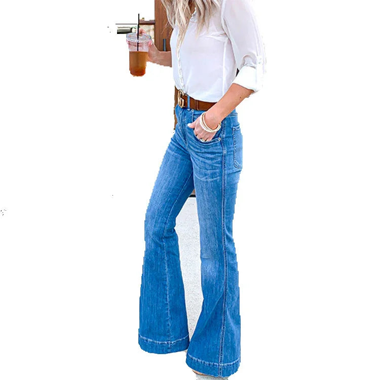 Woman wearing high-waisted blue flared jeans, white blouse, brown belt, holding iced coffee