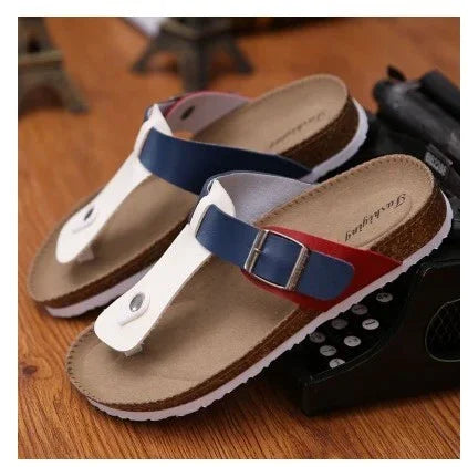Casual unisex sandals with blue, red, and white straps and cork footbed on wooden floor