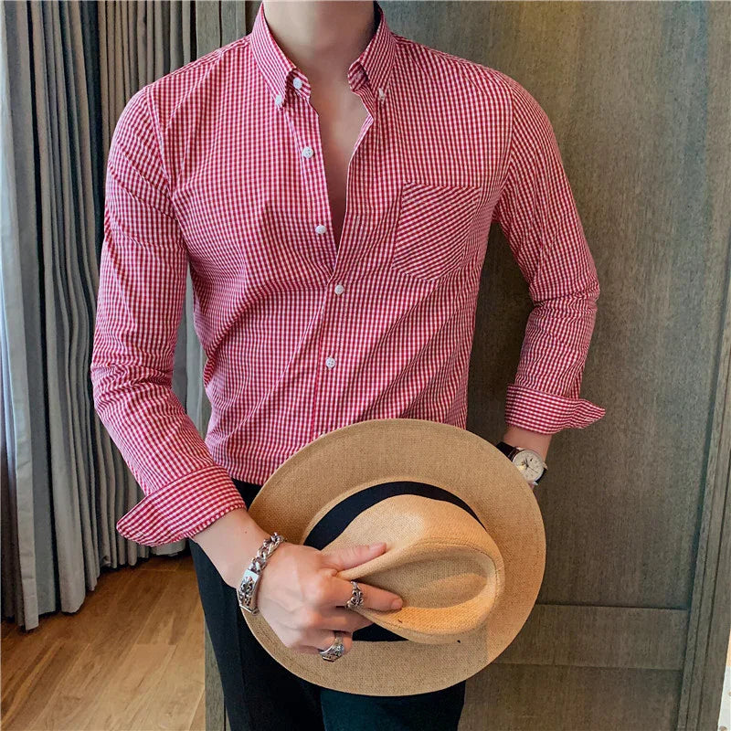 Man wearing red checkered button-up shirt holding a beige straw hat with black band