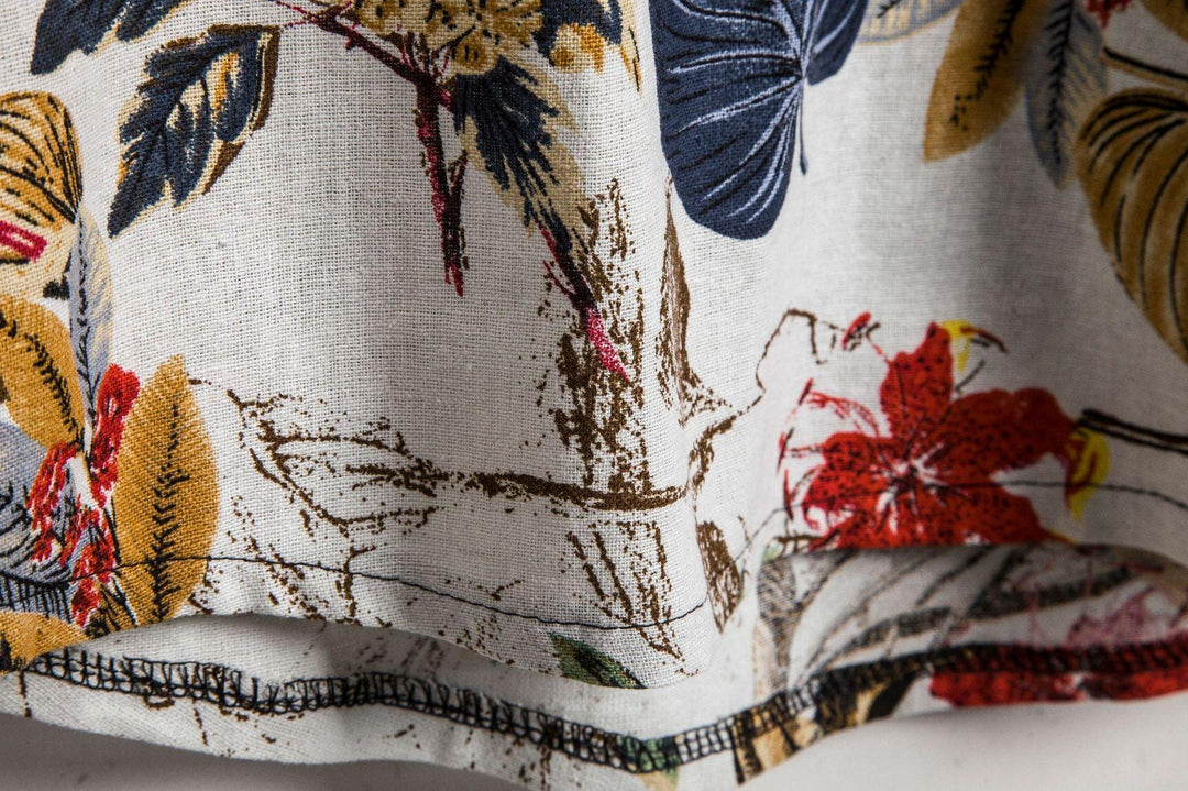 Close-up of linen fabric with colorful floral print and detailed stitching on hem