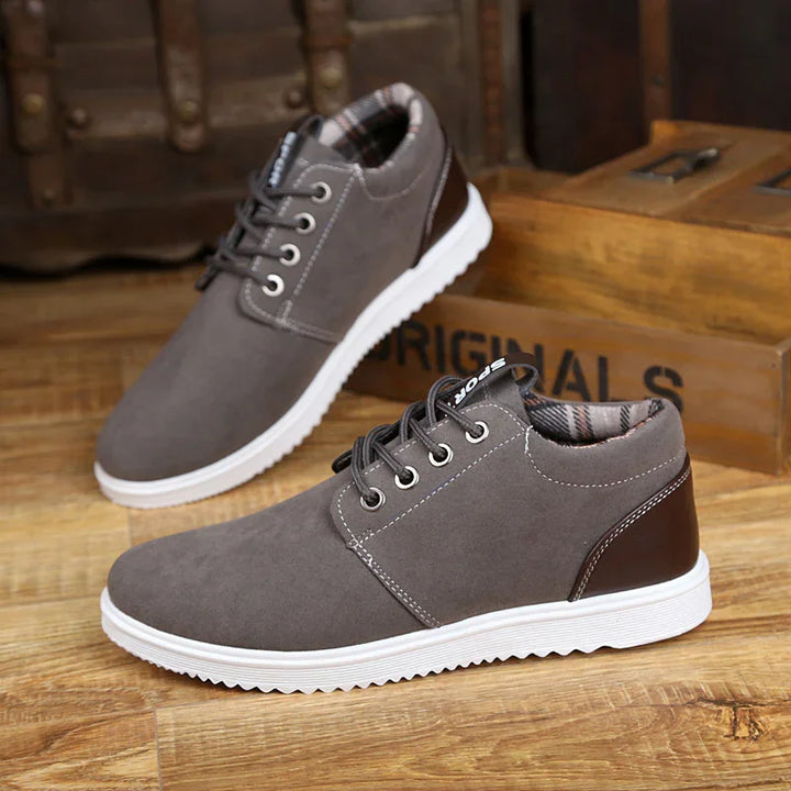 Gray casual men's sneakers with white soles and brown heel accents on wooden floor