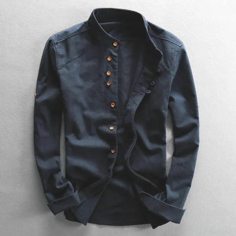 Black long-sleeve mandarin collar shirt with gold buttons on gray background