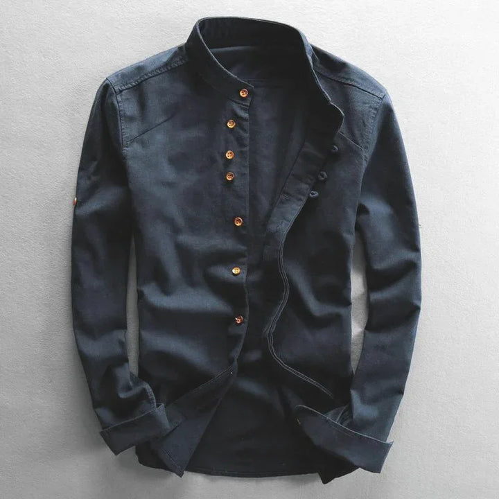 Black long-sleeve mandarin collar shirt with gold buttons on gray background