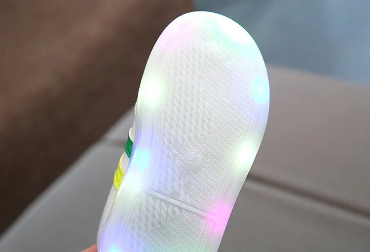 Close-up of white sneaker sole with colorful LED lights glowing around the edges