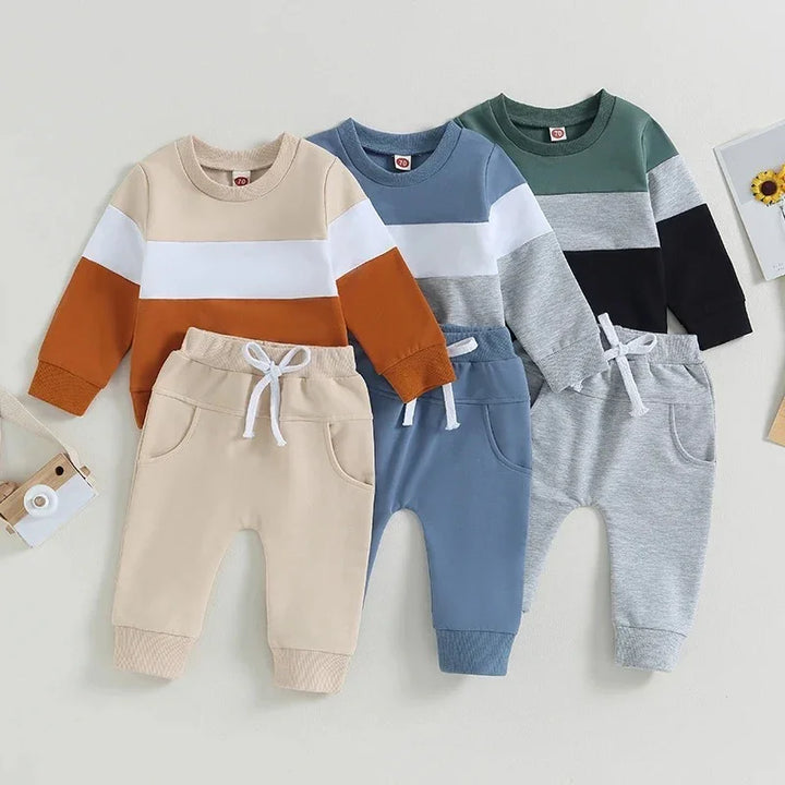 Three toddler color-blocked sweatshirts and pants sets in beige, blue, and green on a light background