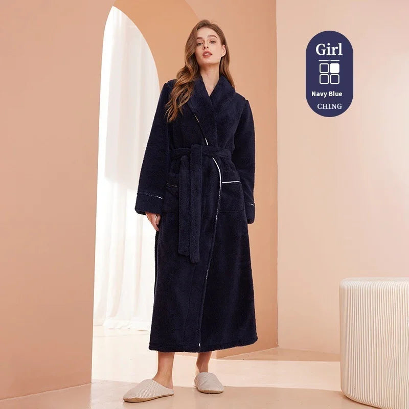 Woman wearing a long navy blue plush bathrobe with belt and slippers in a minimalist room