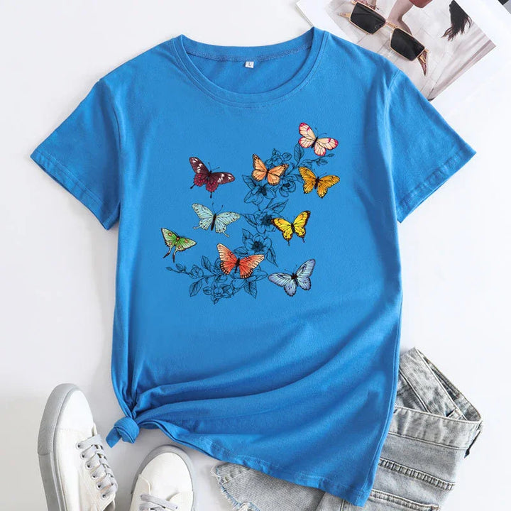 Blue short-sleeve t-shirt with colorful butterfly and floral print, styled with sneakers and denim shorts