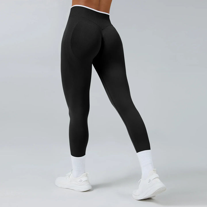 Back view of person wearing black seamless athletic leggings with white trim, white socks, and white sneakers