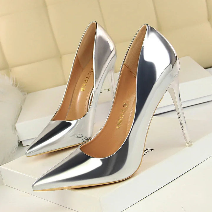 Shiny silver high-heeled stiletto pumps with pointed toes on white boxes