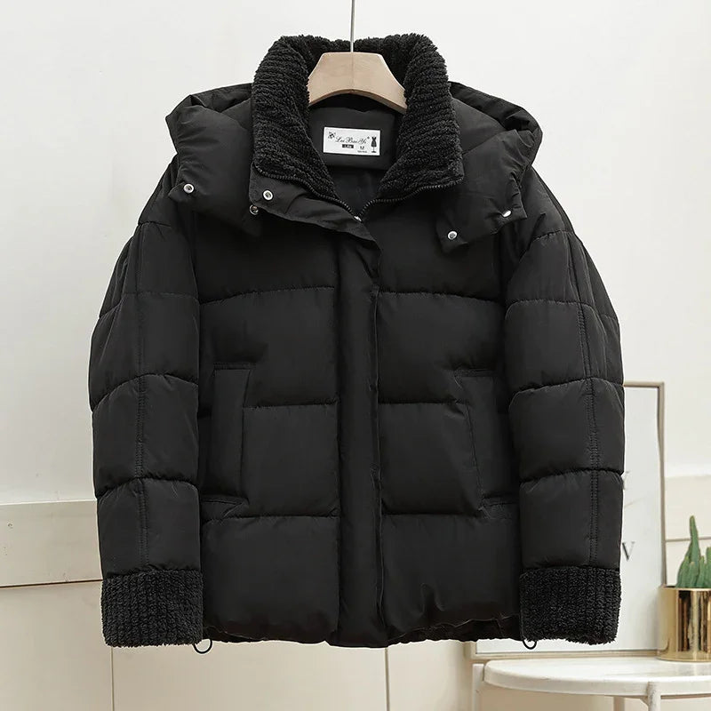 black puffer jacket with knitted collar and cuffs hanging on wooden hanger indoors