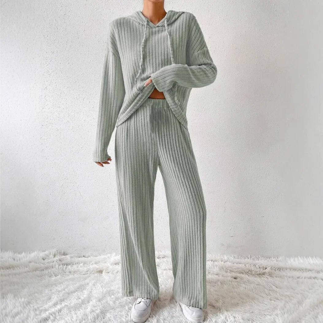 Woman wearing ribbed light gray knit loungewear set with hooded sweater and wide-leg pants