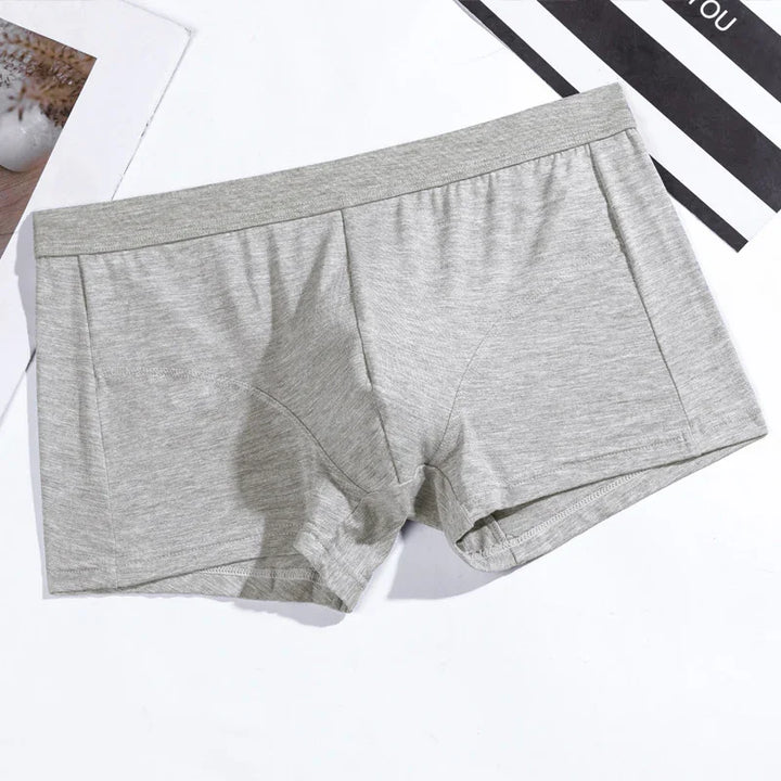 Light gray men's cotton boxer briefs on white surface with black and white background