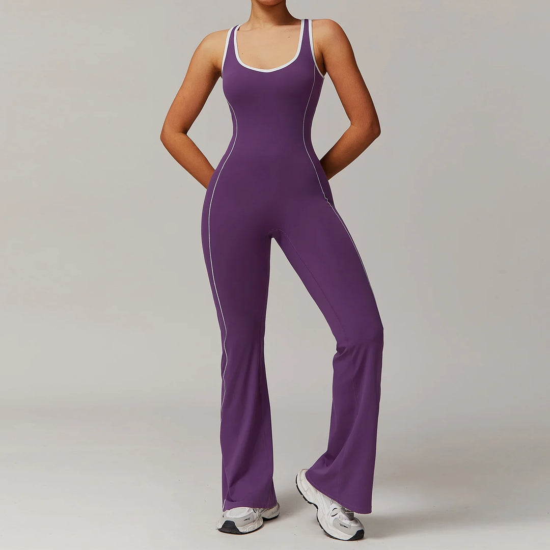 Woman wearing purple sleeveless fitted jumpsuit with white piping and white sneakers