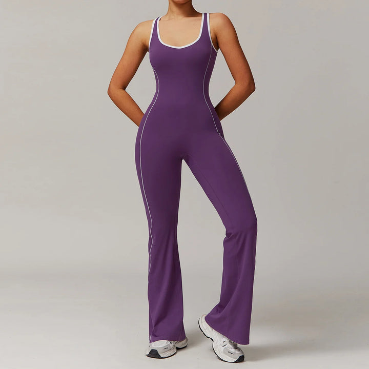 Woman wearing purple sleeveless fitted jumpsuit with white piping and white sneakers