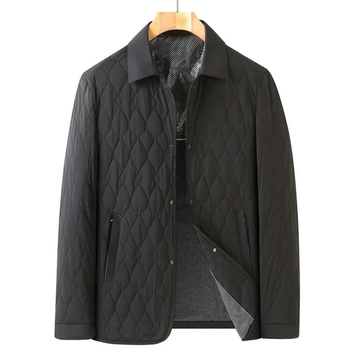 Black quilted men's jacket with snap buttons and zippered pockets on wooden hanger