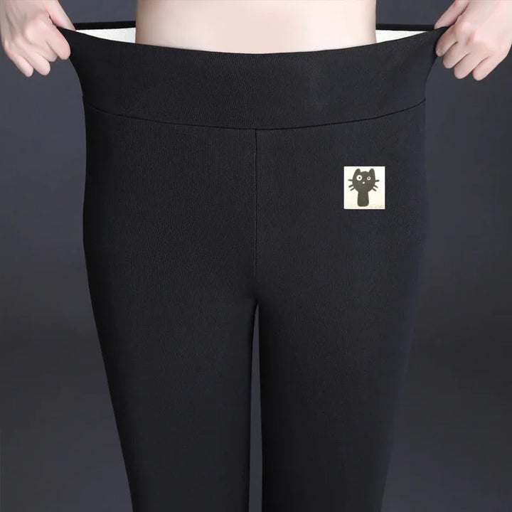 Person stretching waist of black leggings with cute black cat patch on front