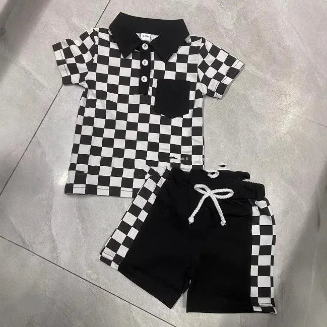 Black and white checkered short sleeve polo shirt with black collar, paired with black shorts with checkered side stripes and white drawstring