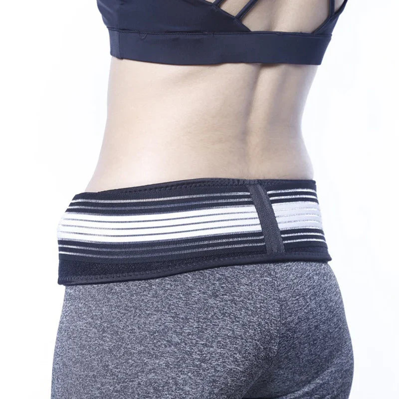 Woman wearing black and white elastic waist support belt over gray athletic leggings