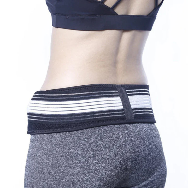 Woman wearing black and white elastic waist support belt over gray athletic leggings