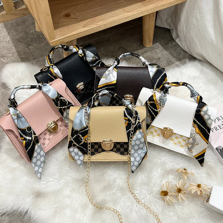 Collection of small leather handbags in pink, black, brown, beige, and white with patterned scarf handles on white fur
