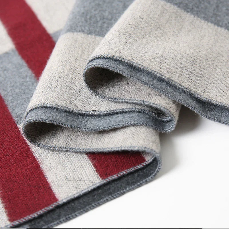 Close-up of folded wool fabric with gray, beige, and red stripes, showcasing soft texture and edges