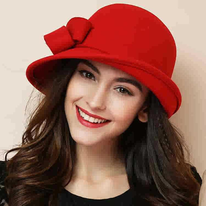 Smiling woman wearing a stylish red felt hat with bow detail and red lipstick