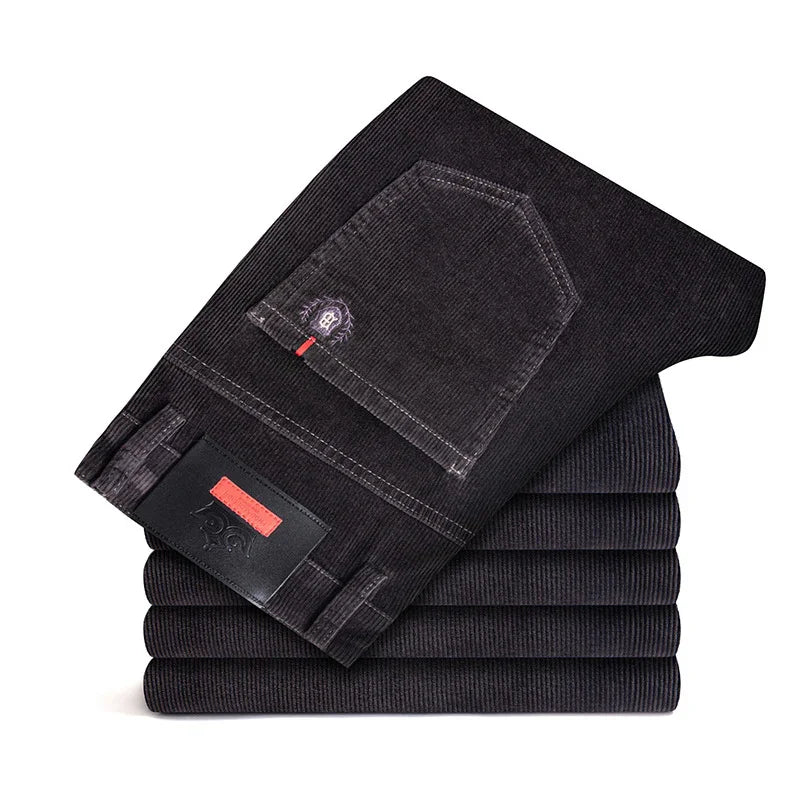Stack of folded black corduroy pants with visible back pocket and brand patch