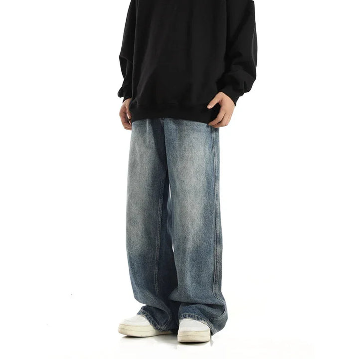Person wearing loose fit light wash jeans with white sneakers and black oversized sweatshirt