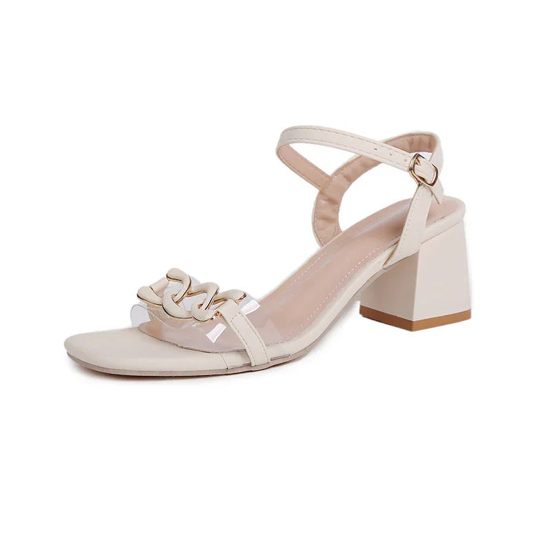Beige block heel sandal with ankle strap and decorative gold chain accent on clear toe strap