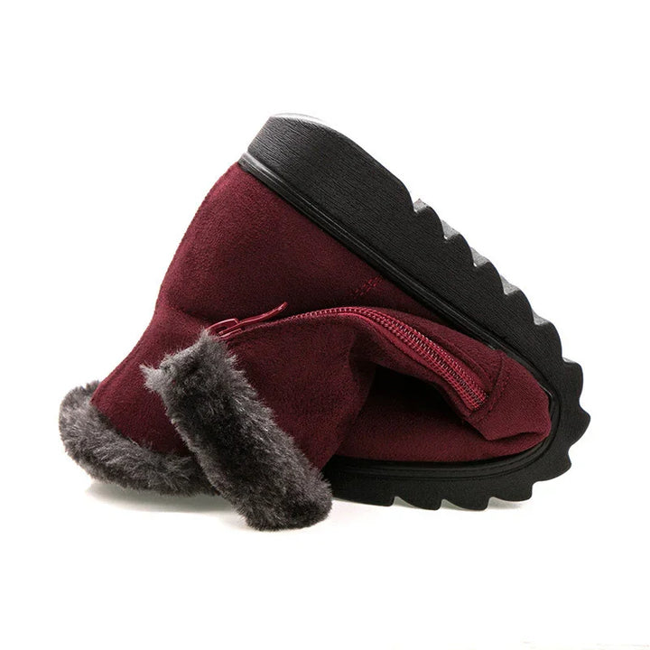 Maroon suede winter boots with gray faux fur trim and black rugged sole on white background