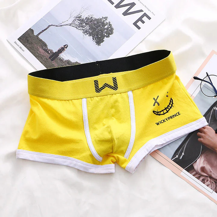 Yellow mens boxer briefs with black waistband, white trim, and WickyPrince smiley face design