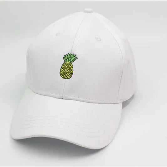 White baseball cap with small embroidered yellow pineapple logo on front