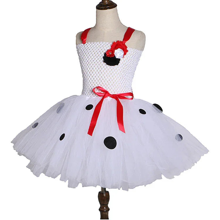 White toddler tutu dress with red straps, black polka dots, red ribbon bow, and flower decoration