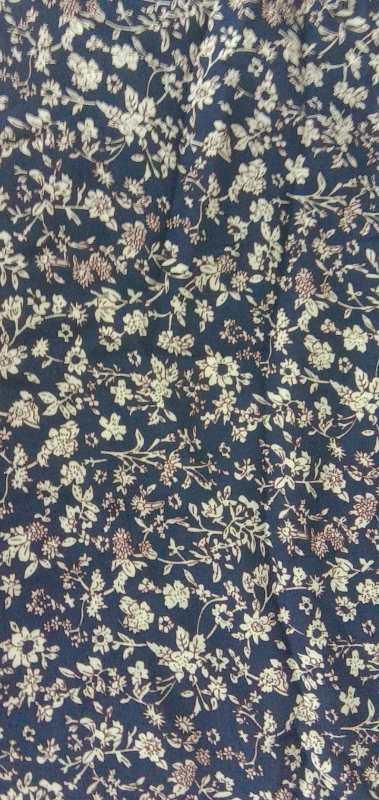 Navy blue fabric with dense light beige floral pattern featuring small flowers and leaves