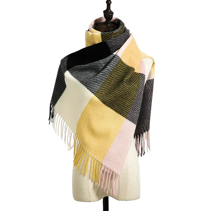 Plaid woolen scarf with fringe in yellow, pink, black, olive, and cream draped on dress form
