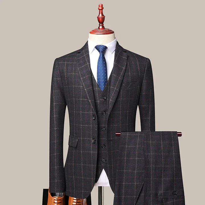 Dark gray plaid three-piece suit with blue polka dot tie on mannequin with brown dress shoes