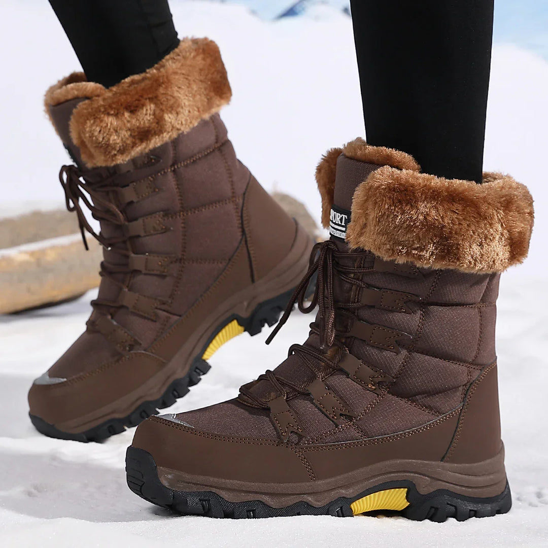 Brown winter snow boots with faux fur lining and black soles worn on snow