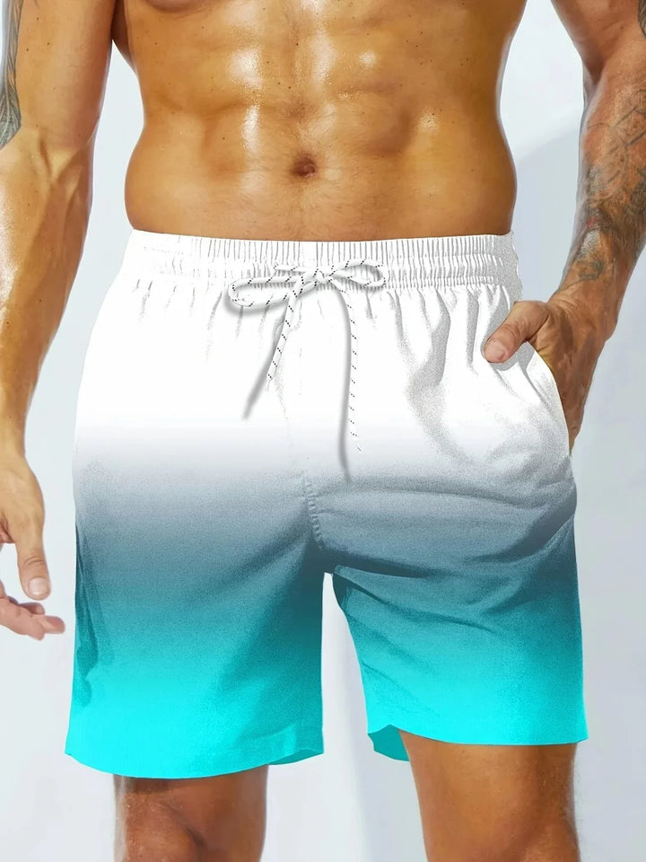 Muscular man wearing blue to white ombre swim trunks with drawstring waist and side pockets