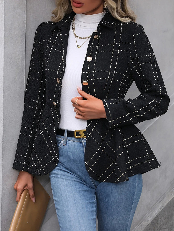 Woman wearing black checkered blazer, white turtleneck, blue jeans, holding brown clutch