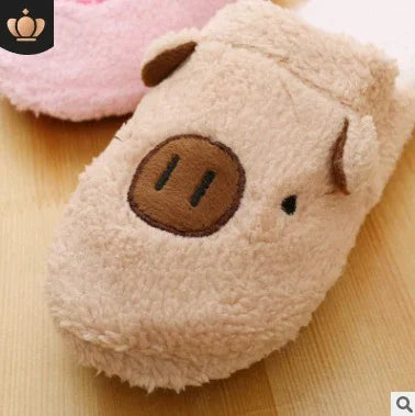 Soft beige plush pig slipper with embroidered snout and ears on wooden floor