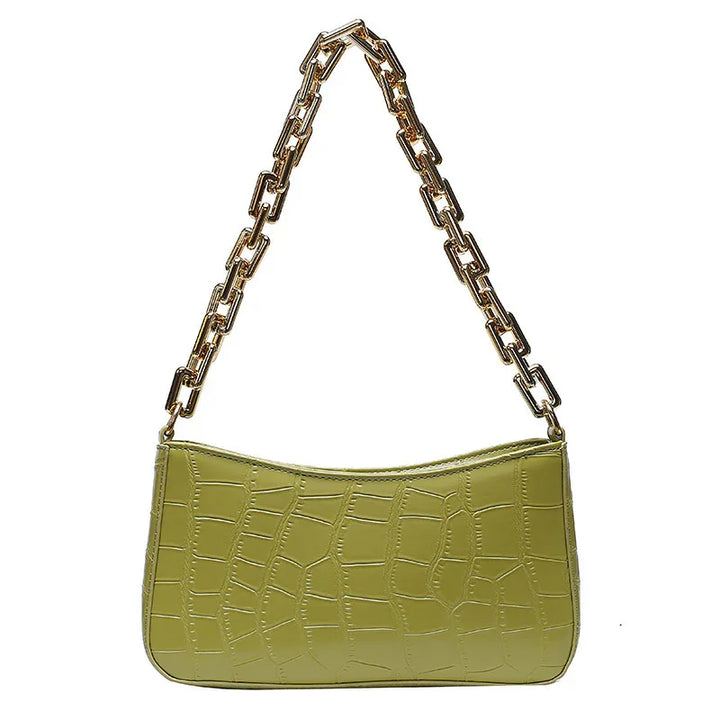 Green crocodile texture handbag with chunky gold chain strap on white background