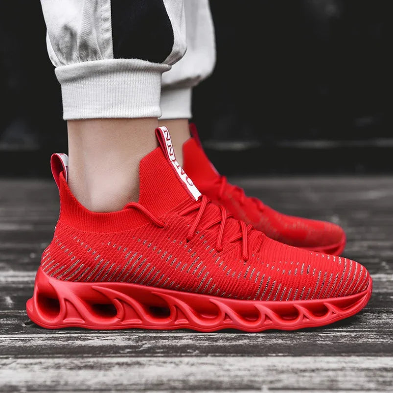 Red knitted running shoes with unique ventilated sole design worn with white cuffed pants