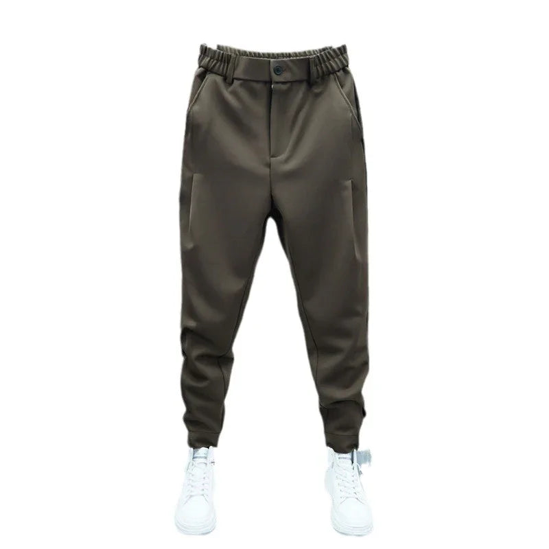 Brown tapered jogger pants with elastic waistband and button, paired with white sneakers