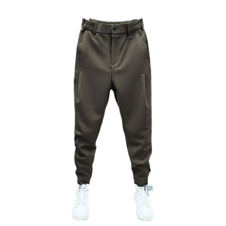 Brown tapered jogger pants with elastic waistband and button, paired with white sneakers