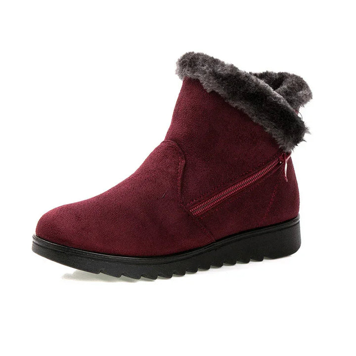 Dark red suede winter ankle boot with black rubber sole and gray faux fur trim